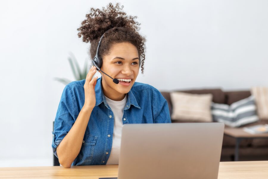 Portrait of happy African American woman employee customer support services or office secretary in headset, online consultation. Call center, customer support or sales female agent