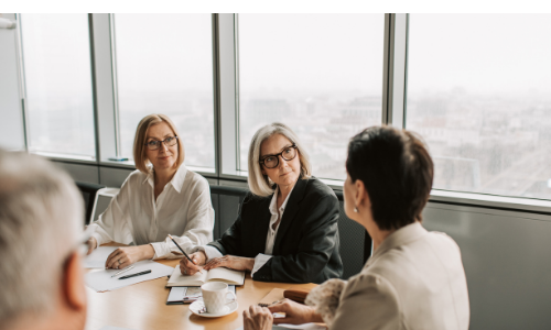 A group of three middle-aged women sat in a meeting room