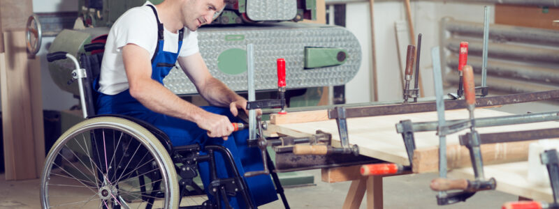 disabled worker in wheelchair in a carpenter's workshop