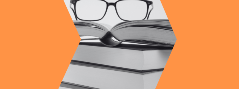 a pair of glasses resting on a pile of books